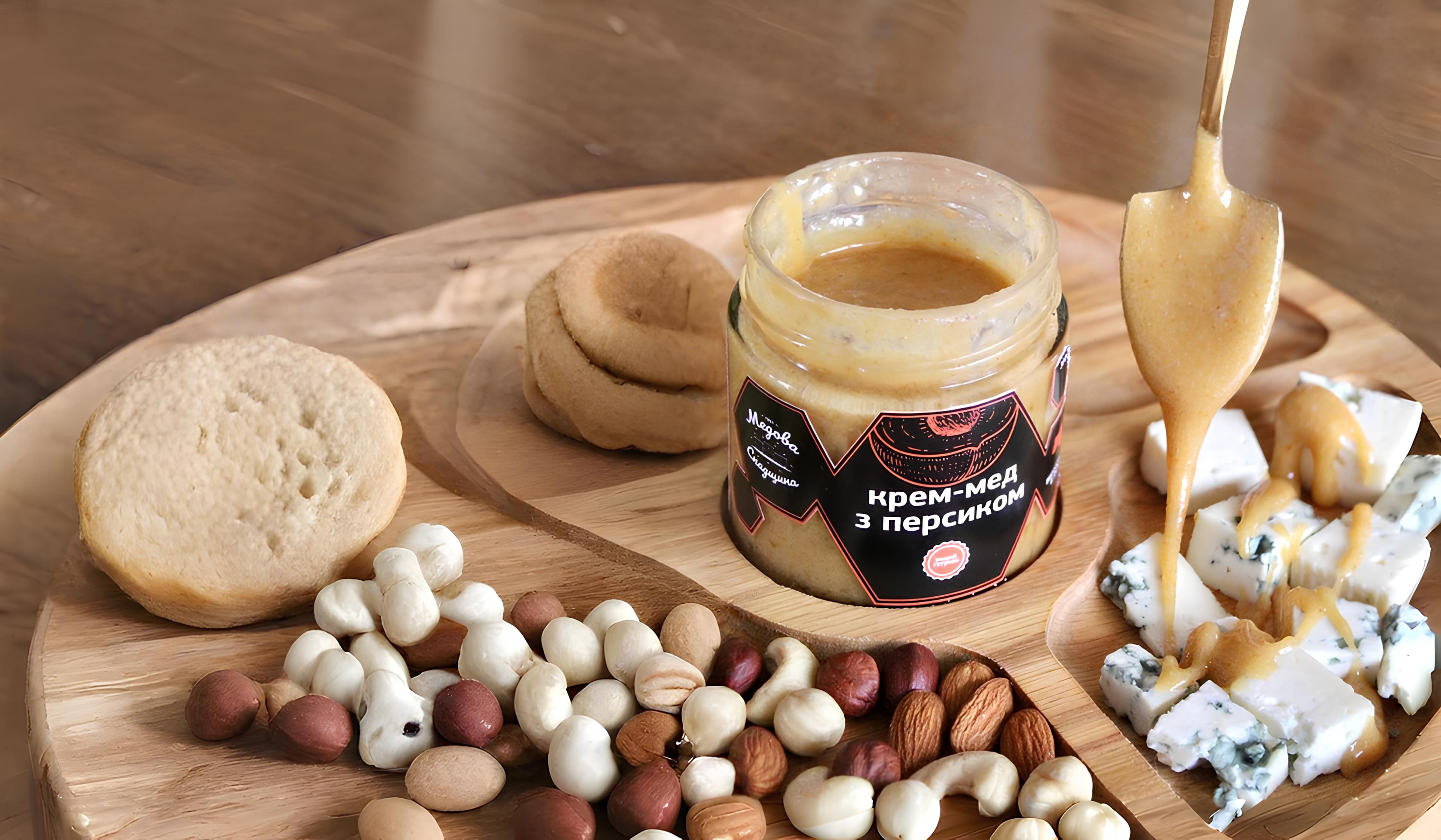 Крем-мед з персиком на дерев'яній дошці з горіхами та сиром